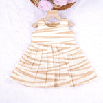 Smiling young girl wearing a sleeveless beige and white striped cotton frock from Boon Babies’ kidswear collection in Coimbatore – perfect for ages 6 months to 5 years.