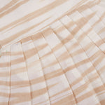 Smiling young girl wearing a sleeveless beige and white striped cotton frock from Boon Babies’ kidswear collection in Coimbatore – perfect for ages 6 months to 5 years.