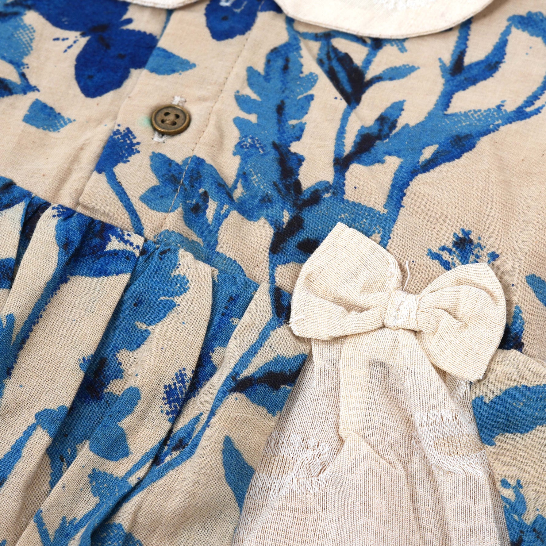 Blue bird print cotton Side Pleated Frock with cream collar & bow. Ages 6M–4Y. Soft, breathable & stylish festive wear for baby girls.