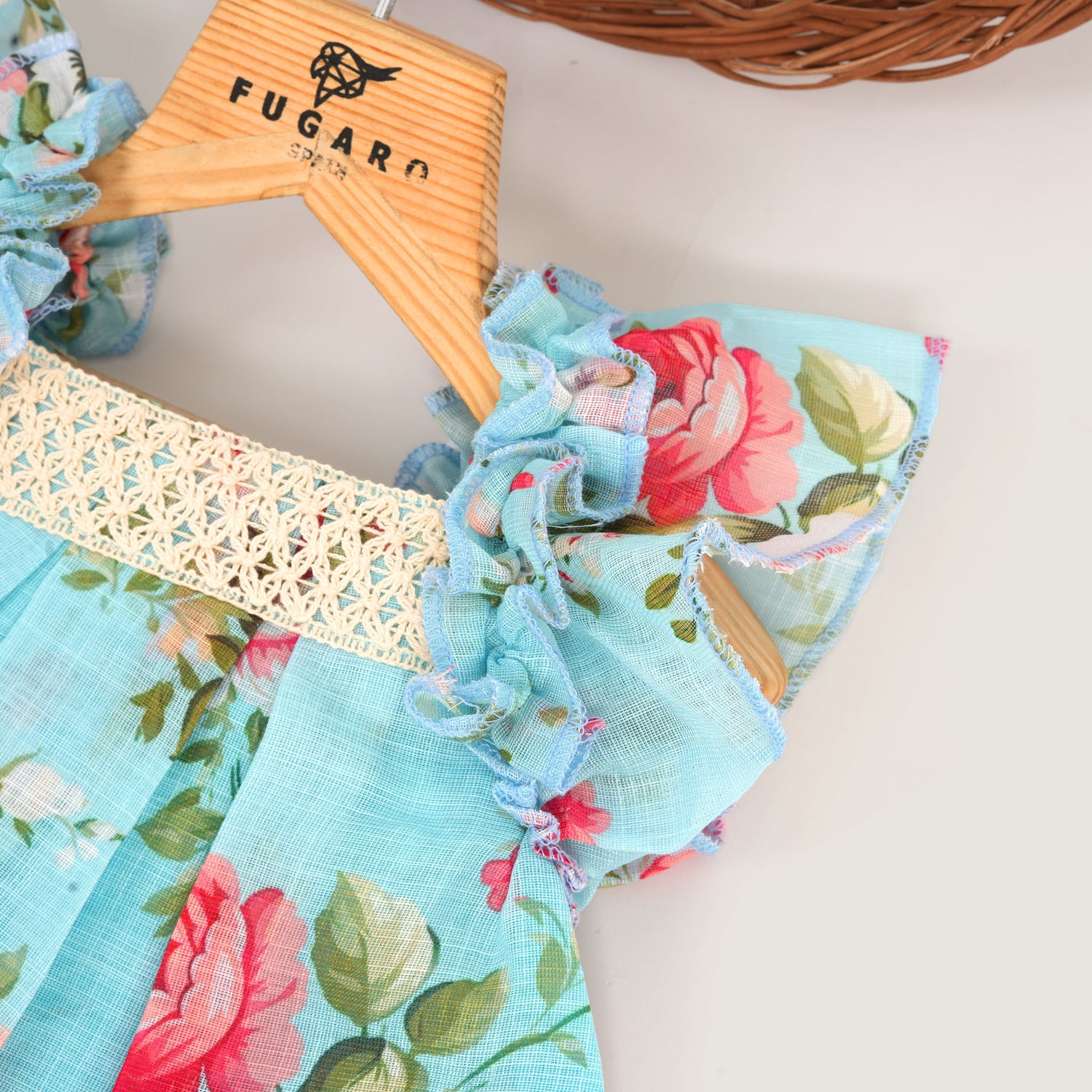 Charming linen baby frock in blue floral print with ruffled sleeves and lace yoke. Available for 6 months to 4 years.
