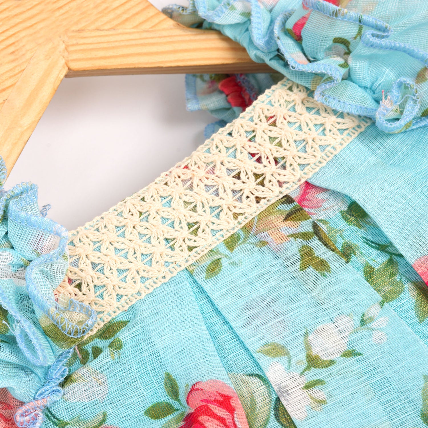 Charming linen baby frock in blue floral print with ruffled sleeves and lace yoke. Available for 6 months to 4 years.
