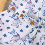 Baby girl wearing a white sleeveless frock with blue reindeer prints, made from slub cotton – part of the Boon Babies kidswear collection in Coimbatore.