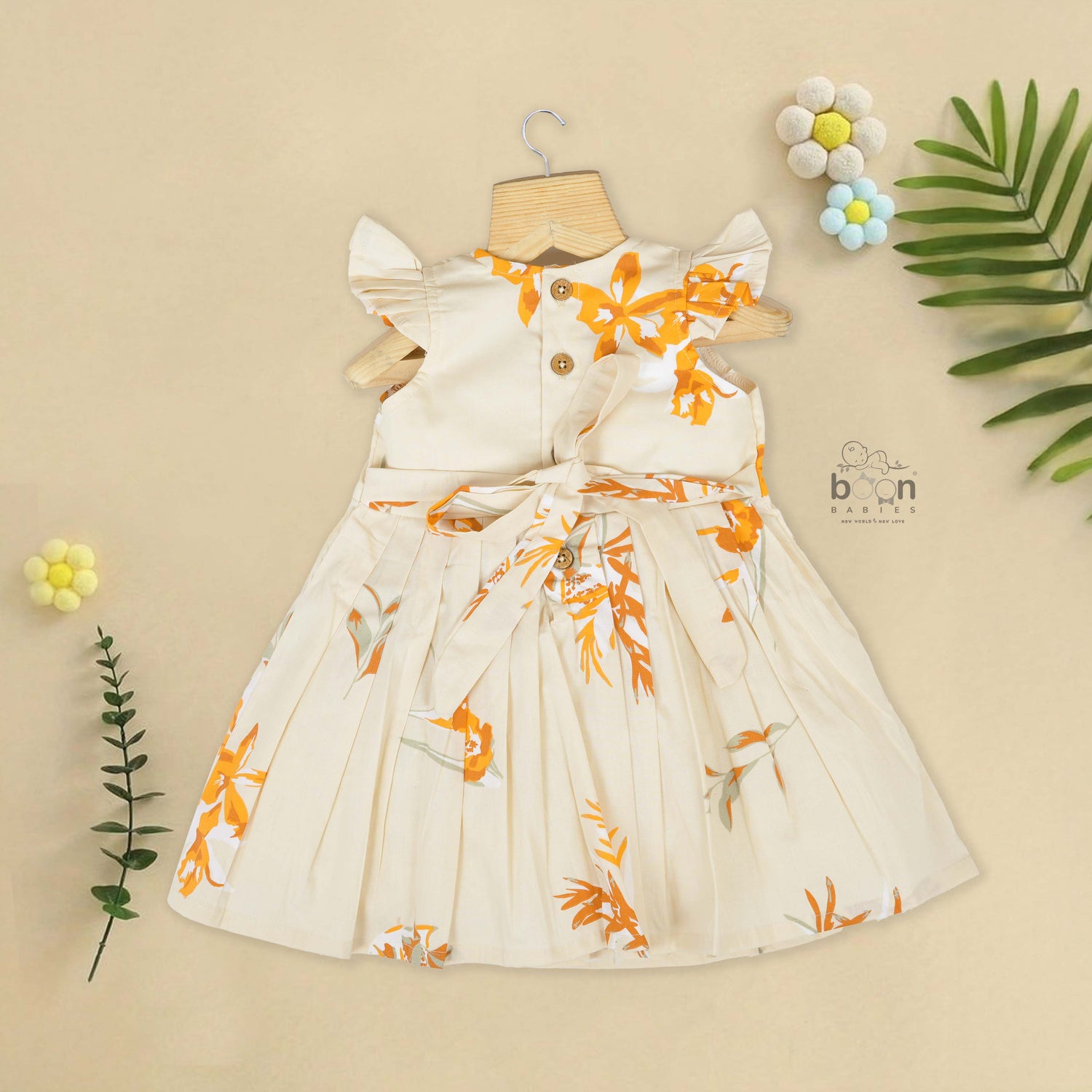 Elegant cream floral frock with flutter sleeves, made from breathable cotton. Available for 6 months to 5 years. A perfect daily wear from Boon Babies.
