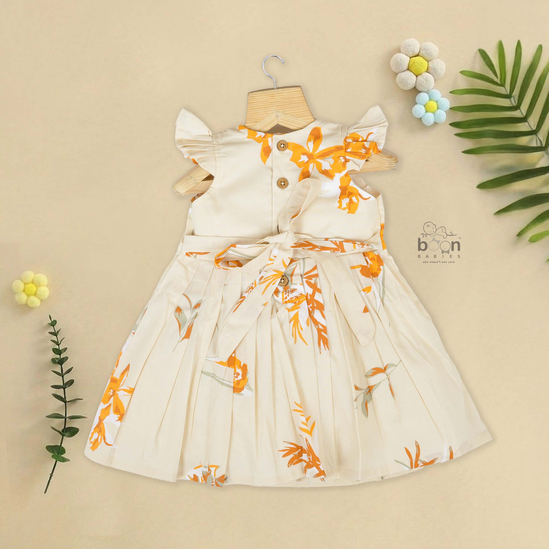 Elegant cream floral frock with flutter sleeves, made from breathable cotton. Available for 6 months to 5 years. A perfect daily wear from Boon Babies.
