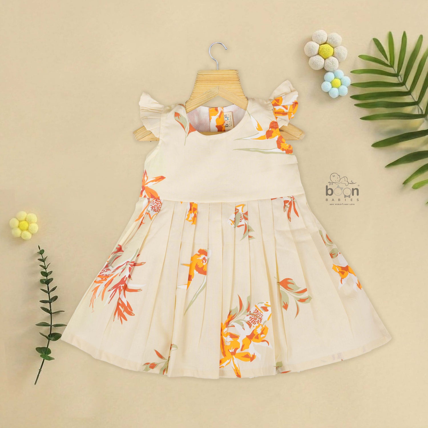Elegant cream floral frock with flutter sleeves, made from breathable cotton. Available for 6 months to 5 years. A perfect daily wear from Boon Babies.
