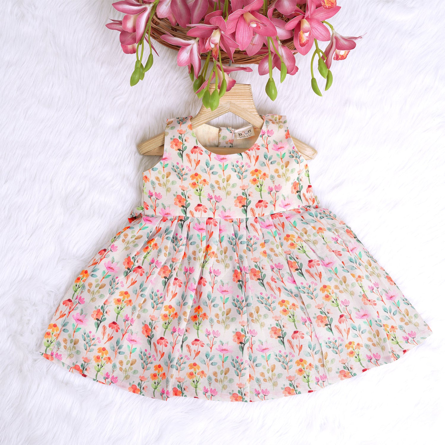Baby girl in a white sleeveless floral frock made of slub cotton, designed for 6 months to 5 years – part of the Boon Babies kidswear collection in Coimbatore.
