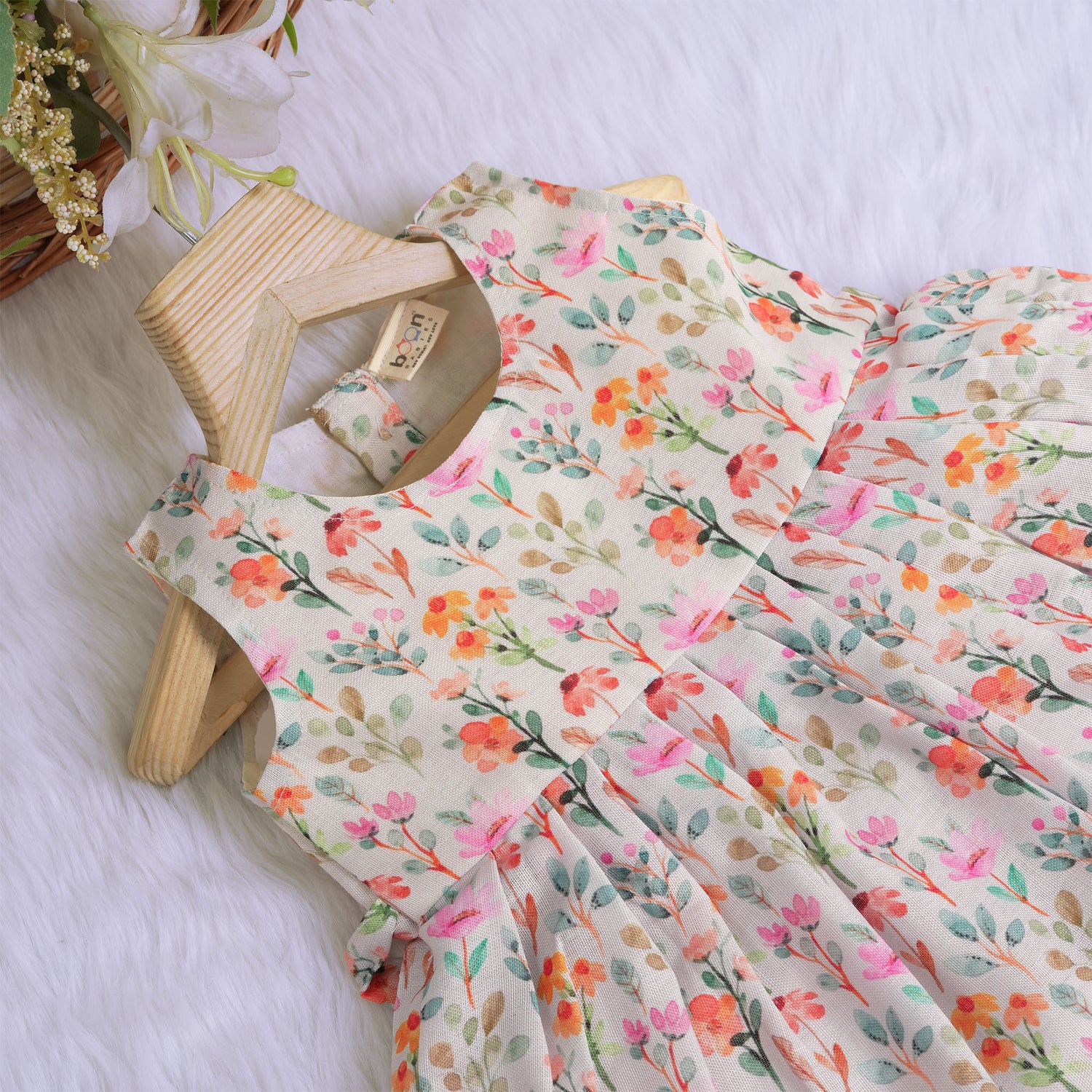 Baby girl in a white sleeveless floral frock made of slub cotton, designed for 6 months to 5 years – part of the Boon Babies kidswear collection in Coimbatore.