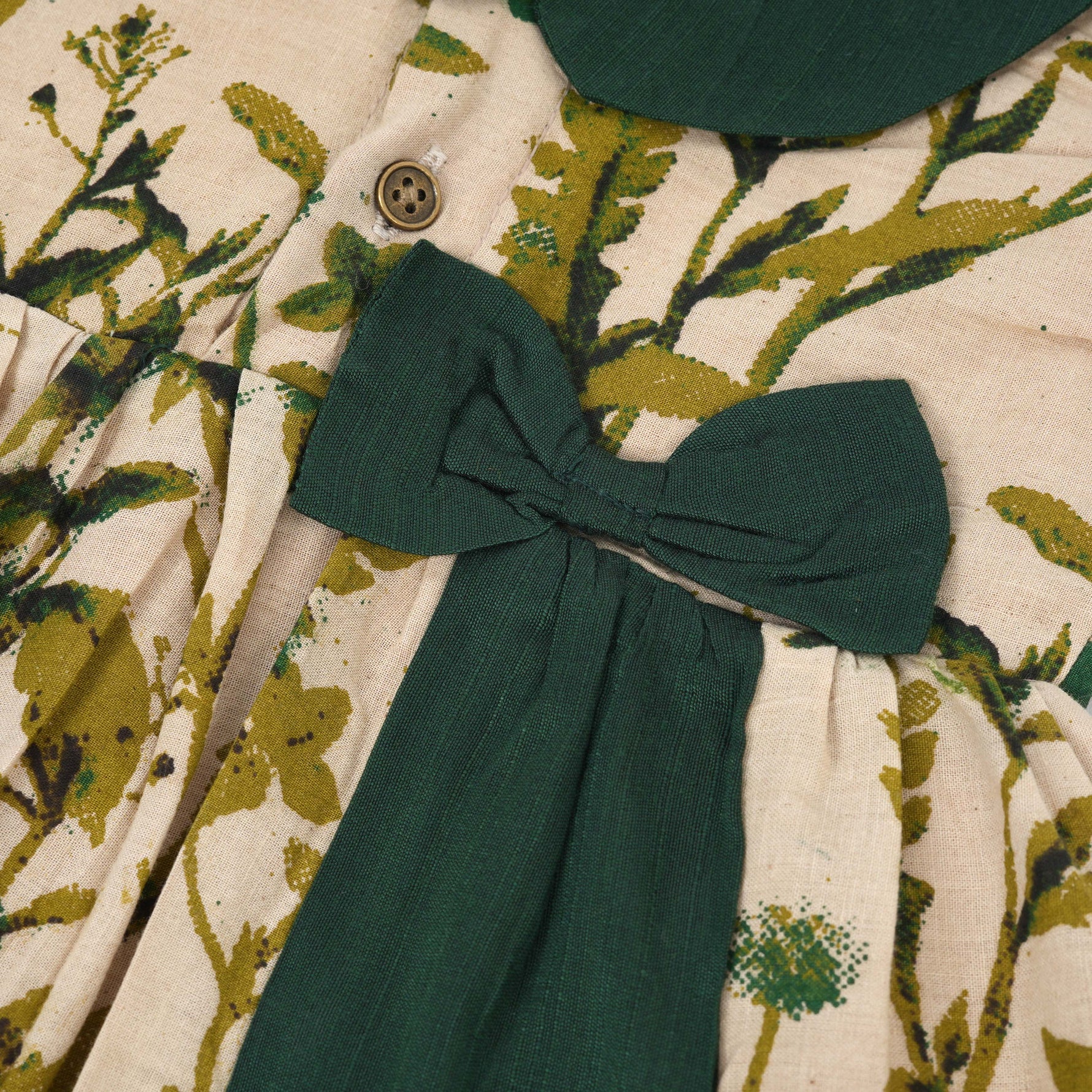 Nature-inspired bird print cotton Side Pleated Frock with green collar & bow. Ages 6M–4Y. Soft, breathable & stylish everyday festive wear.