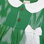 Green ikat print cotton puff frock with white collar & bow. Ages 6M–4Y. Soft, breathable & stylish festive wear for baby girls.