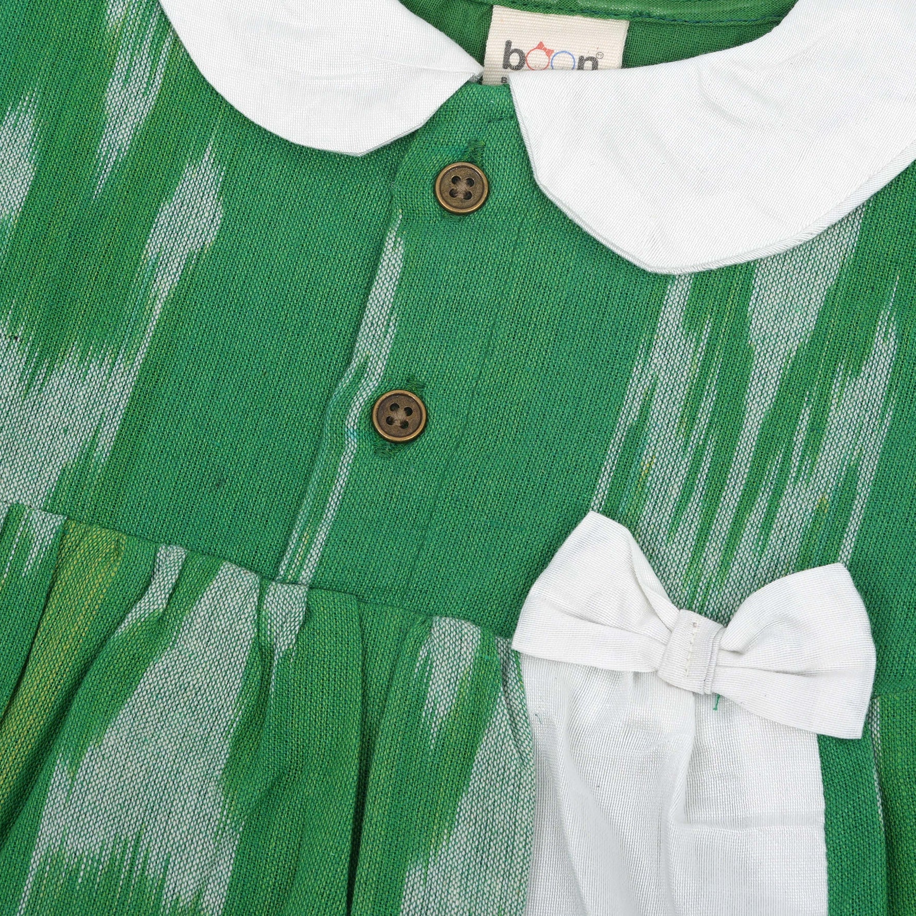 Green ikat print cotton puff frock with white collar & bow. Ages 6M–4Y. Soft, breathable & stylish festive wear for baby girls.