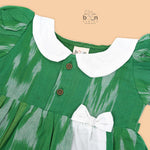 Green ikat print cotton puff frock with white collar & bow. Ages 6M–4Y. Soft, breathable & stylish festive wear for baby girls.
