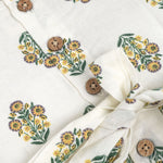 Toddler girl wearing an ivory sleeveless cotton frock with traditional floral butta print – ethnic babywear from Boon Babies, Coimbatore.