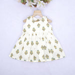 Toddler girl wearing an ivory sleeveless cotton frock with traditional floral butta print – ethnic babywear from Boon Babies, Coimbatore.