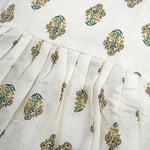 Toddler girl wearing an ivory sleeveless cotton frock with traditional floral butta print – ethnic babywear from Boon Babies, Coimbatore.