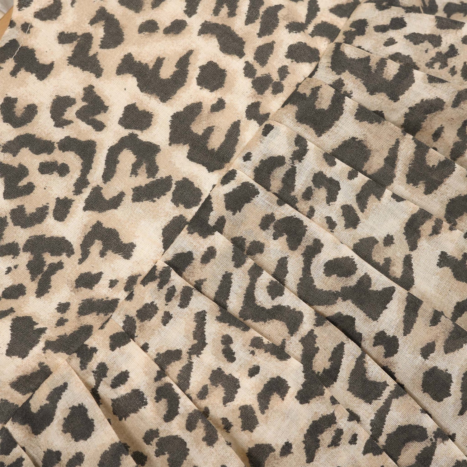 Leopard print sleeveless cotton frock for girls aged 12M–5Y, with a flared pleated skirt – displayed on a wooden hanger with white roses in the background.