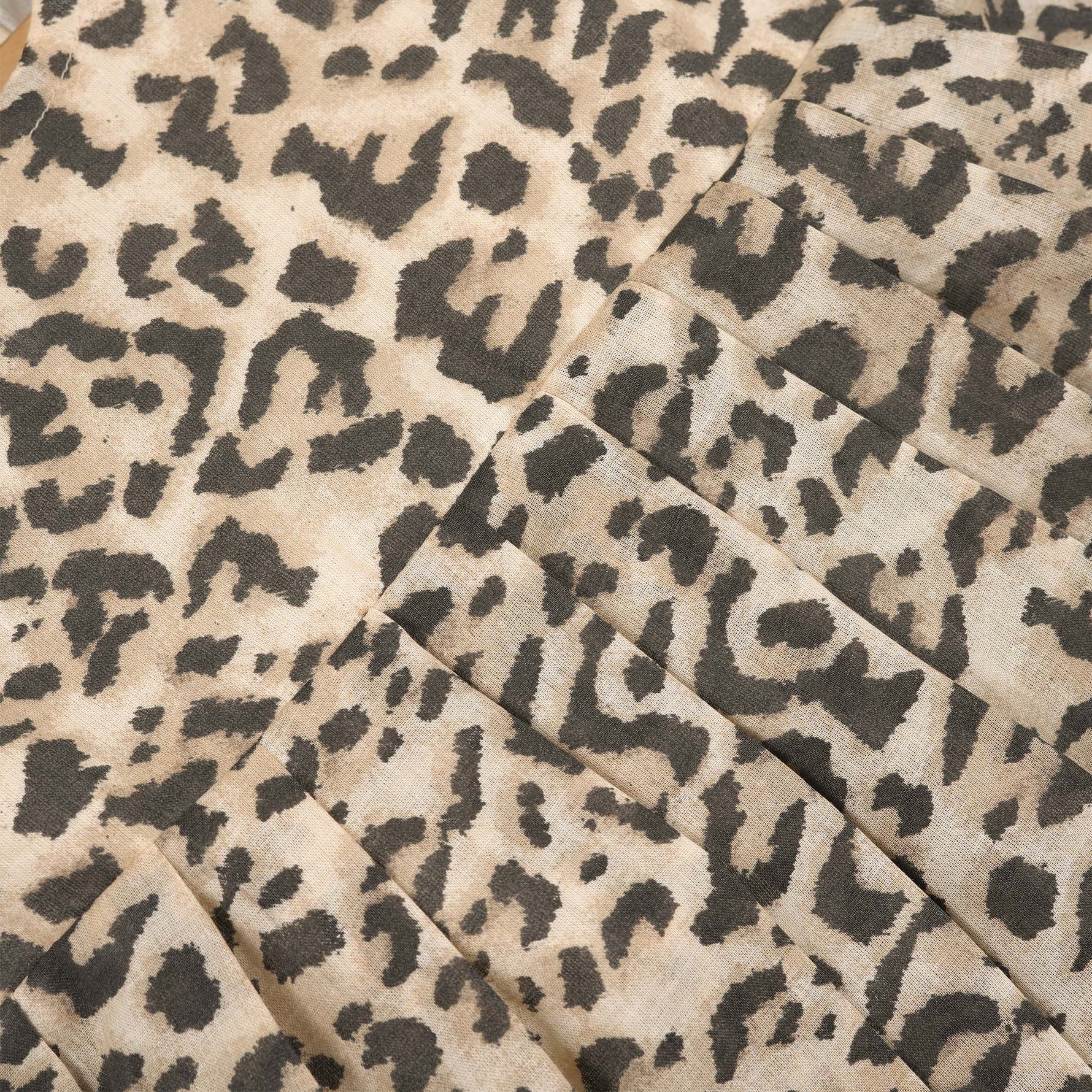 Leopard print sleeveless cotton frock for girls aged 12M–5Y, with a flared pleated skirt – displayed on a wooden hanger with white roses in the background.