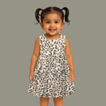 Leopard print sleeveless cotton frock for girls aged 12M–5Y, with a flared pleated skirt – displayed on a wooden hanger with white roses in the background.