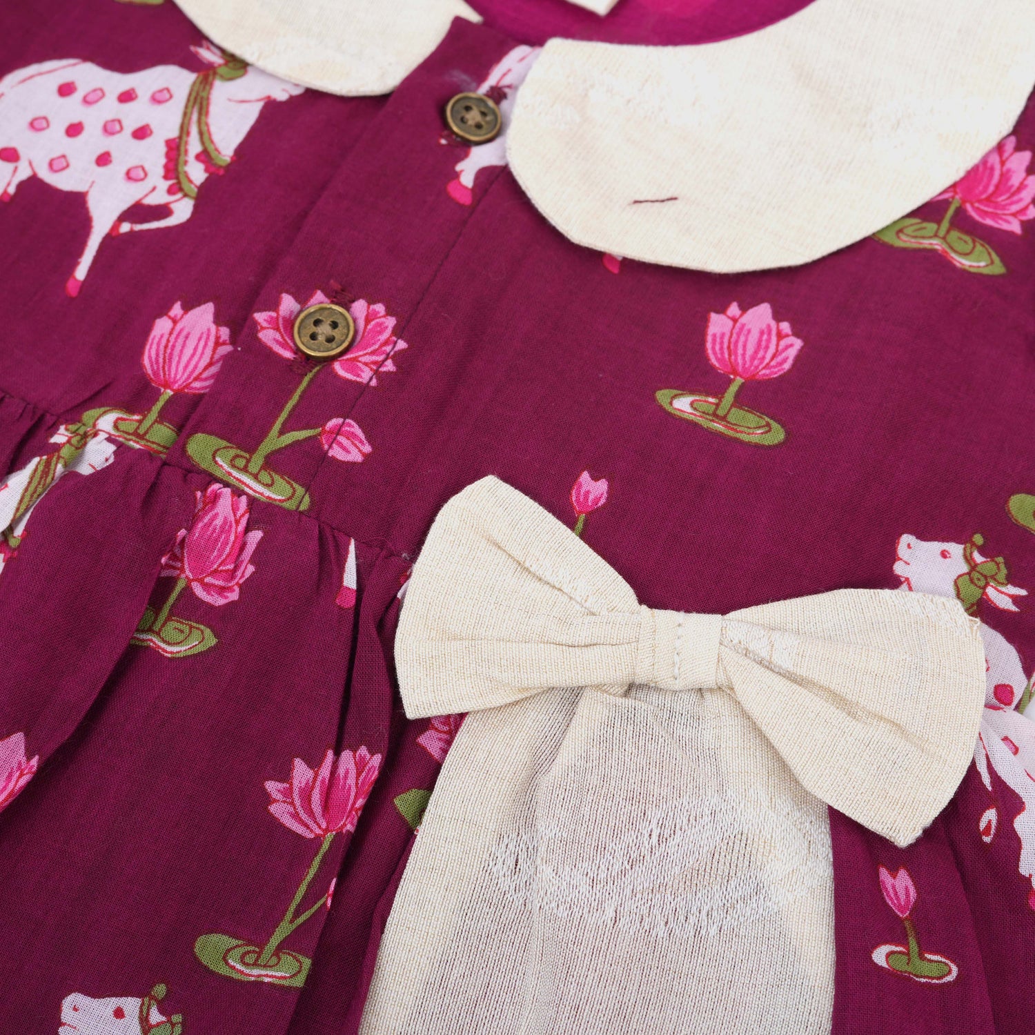 Maroon cotton puff frock with front collar, bow tie & lotus print. Stylish & comfy for girls aged 6M–4Y.
