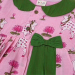 Pink cotton puff frock with green bow, contrast collar & lotus cow print. Cute, festive & comfy for baby girls aged 6M–4Y.