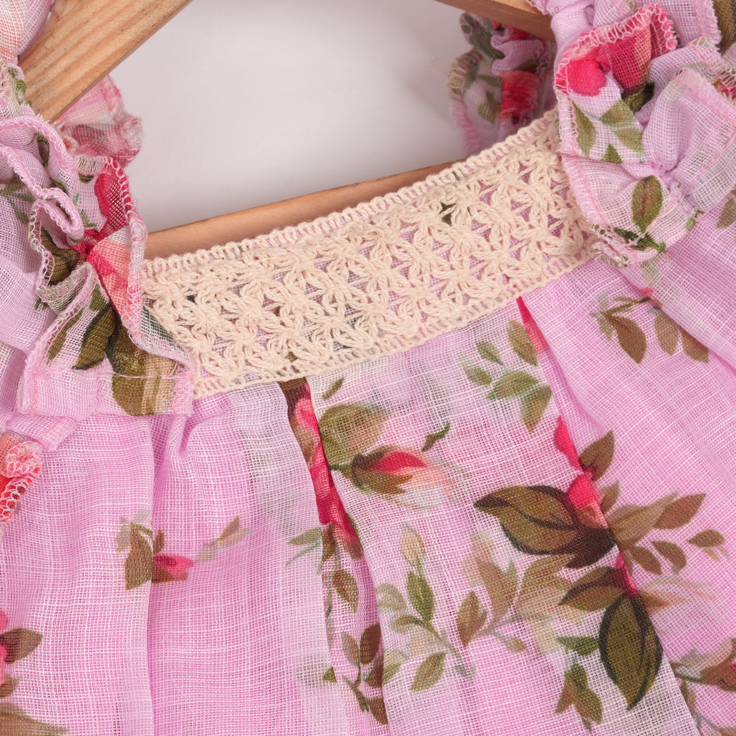 Adorable pink floral frock with ruffle sleeves in breathable linen. Sizes 6M–4Y. Perfect for stylish little girls.
