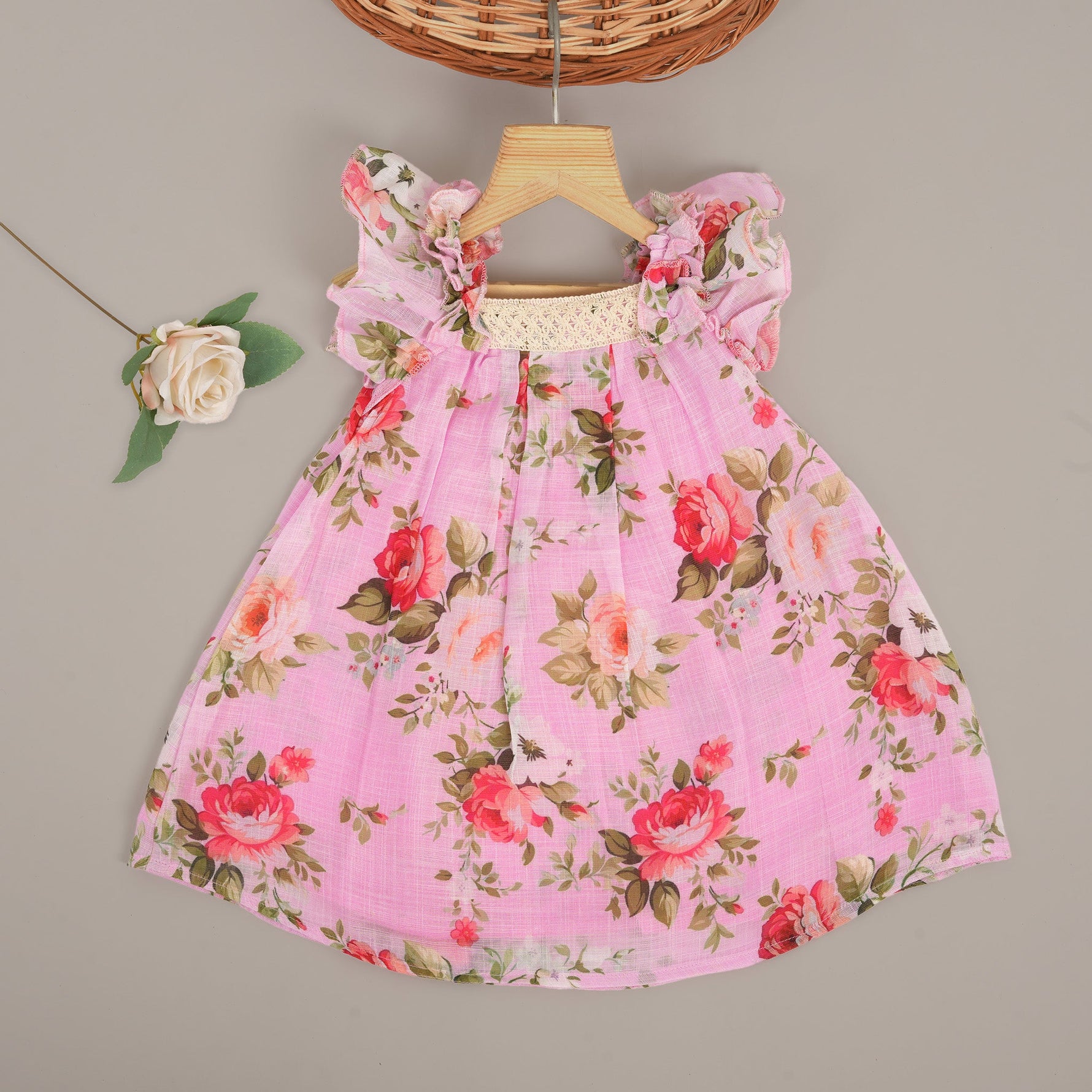 Adorable pink floral frock with ruffle sleeves in breathable linen. Sizes 6M–4Y. Perfect for stylish little girls.
