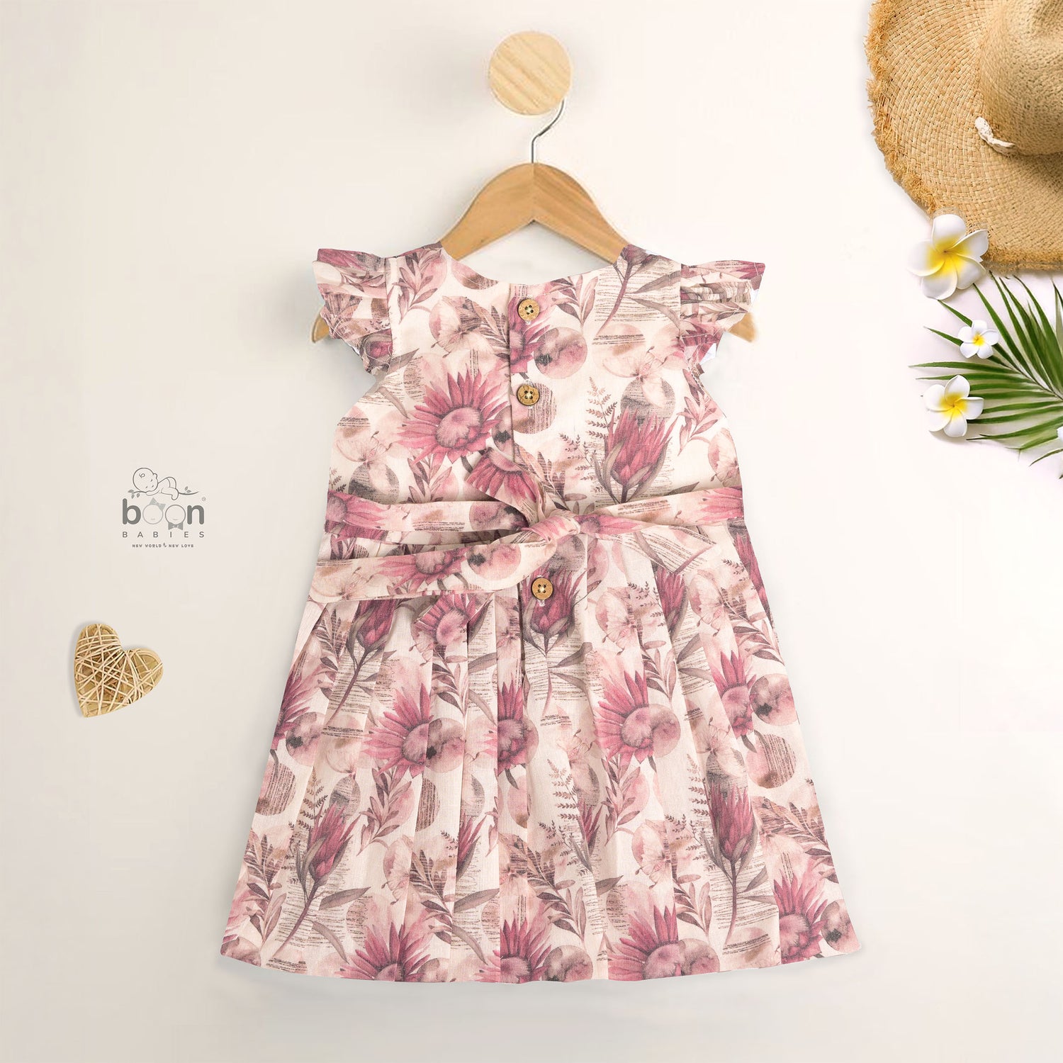 Pink floral cotton frock for girls with ruffle cap sleeves, designed for 6 months to 5 years – from Boon Babies clothing collection in Coimbatore.
