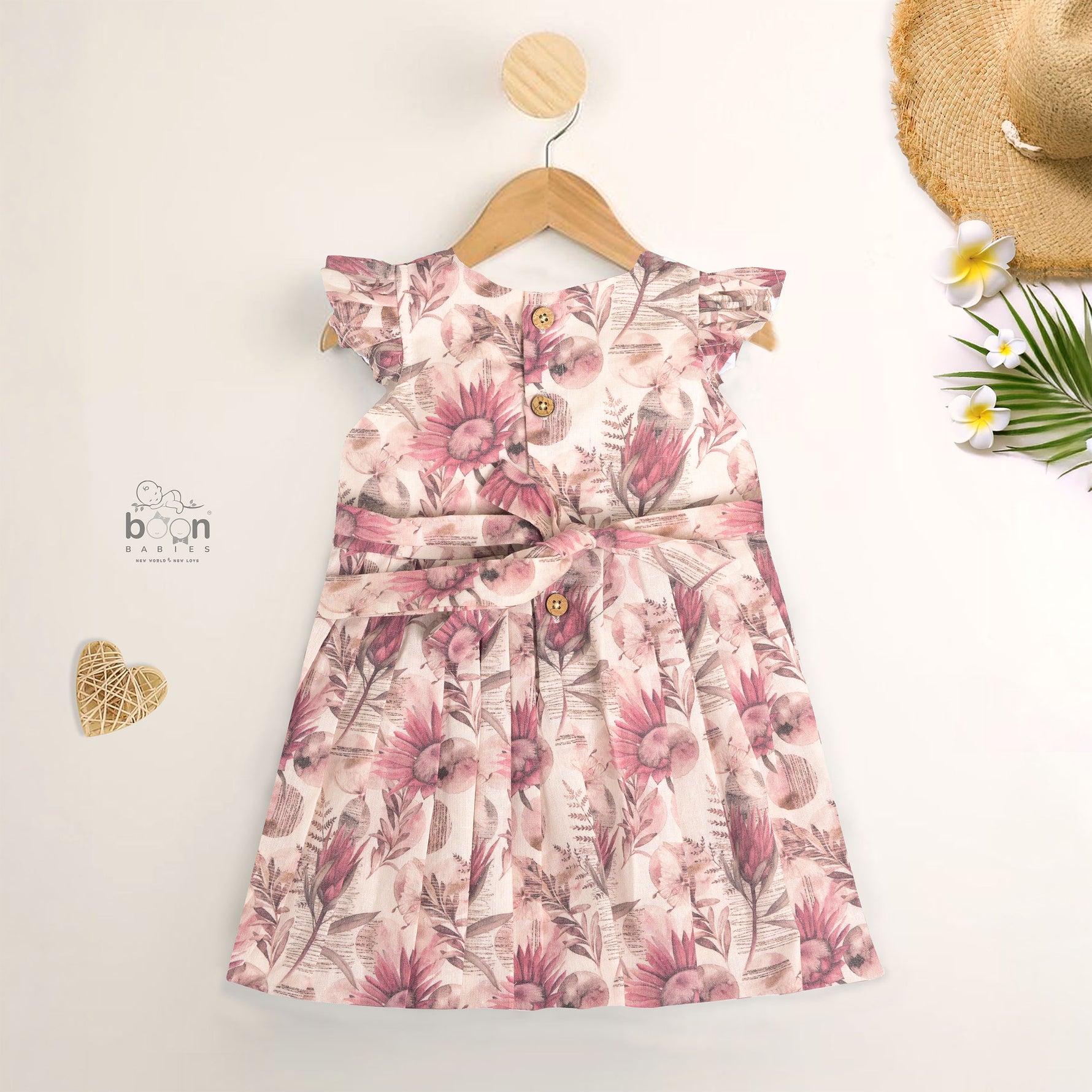 Pink floral cotton frock for girls with ruffle cap sleeves, designed for 6 months to 5 years – from Boon Babies clothing collection in Coimbatore.
