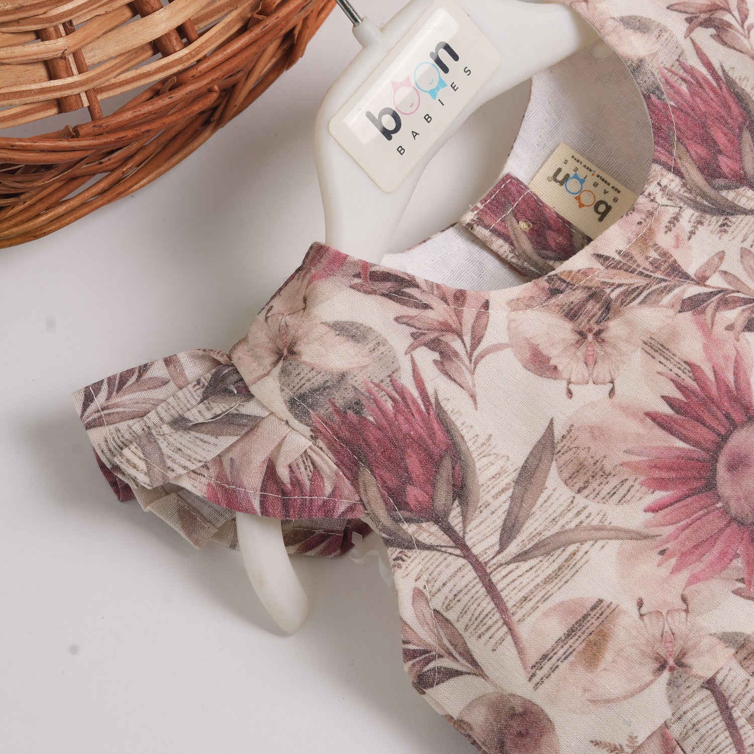 Pink floral cotton frock for girls with ruffle cap sleeves, designed for 6 months to 5 years – from Boon Babies clothing collection in Coimbatore.
