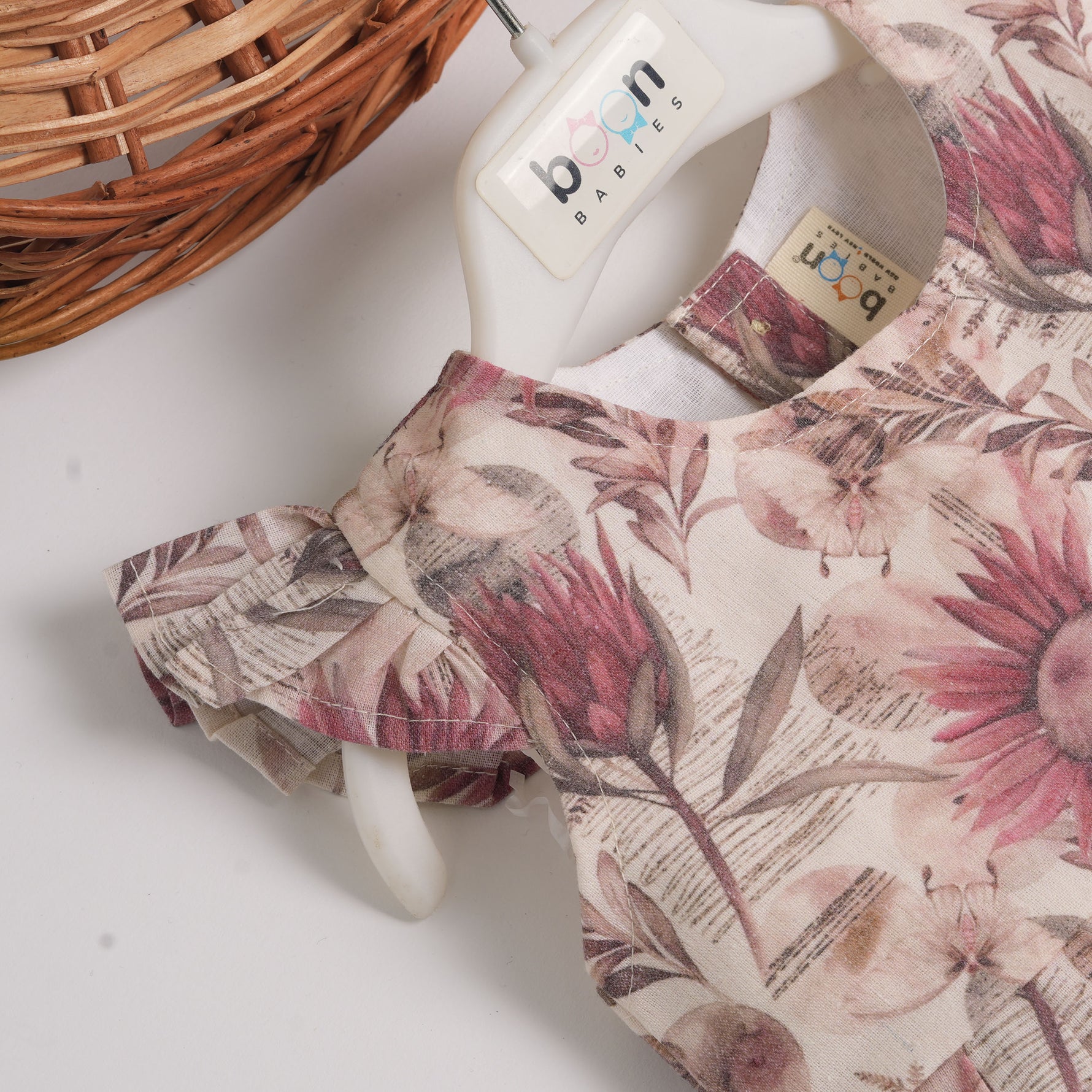 Pink floral cotton frock for girls with ruffle cap sleeves, designed for 6 months to 5 years – from Boon Babies clothing collection in Coimbatore.
