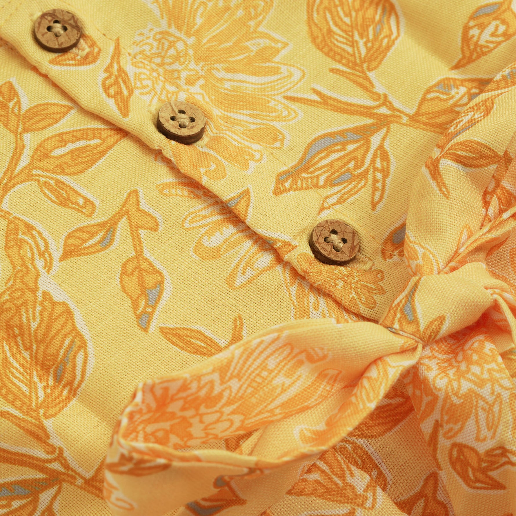 Sunshine yellow sleeveless slub cotton frock for baby girls with all-over orange floral print and pleated skirt, displayed flat on a white fur background with floral basket hanger.