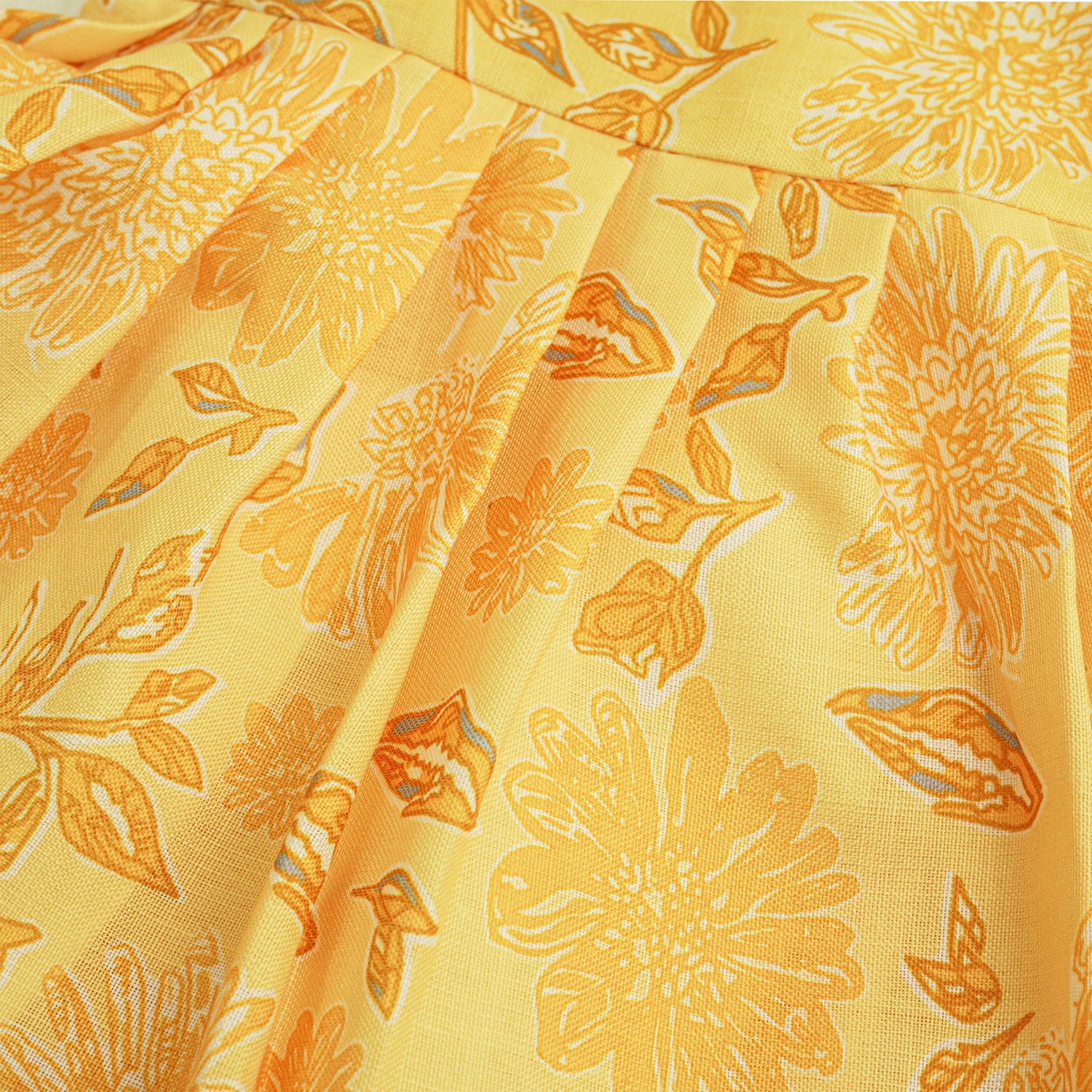 Sunshine yellow sleeveless slub cotton frock for baby girls with all-over orange floral print and pleated skirt, displayed flat on a white fur background with floral basket hanger.