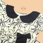 Black & white cotton Side Pleated Frock with floral print, contrast collar & bow detail. Stylish & comfy for baby girls aged 6M–4Y.
