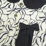 Black & white cotton Side Pleated Frock with floral print, contrast collar & bow detail. Stylish & comfy for baby girls aged 6M–4Y.