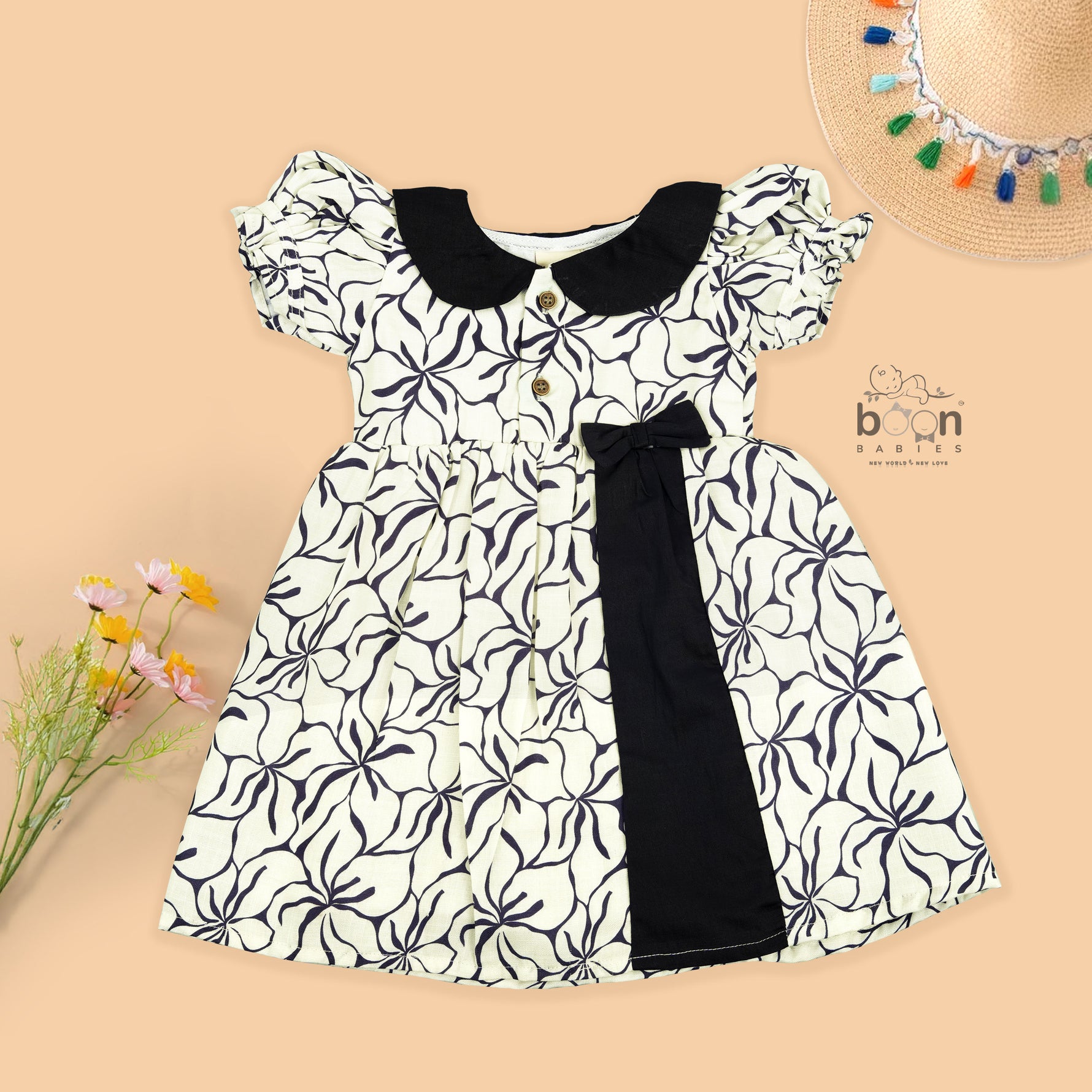Black & white cotton Side Pleated Frock with floral print, contrast collar & bow detail. Stylish & comfy for baby girls aged 6M–4Y.