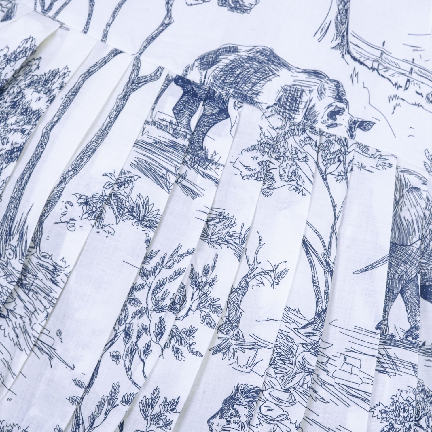 Toddler girl wearing a white and blue sleeveless cotton frock with forest and elephant print – soft summer wear from Boon Babies, Coimbatore.