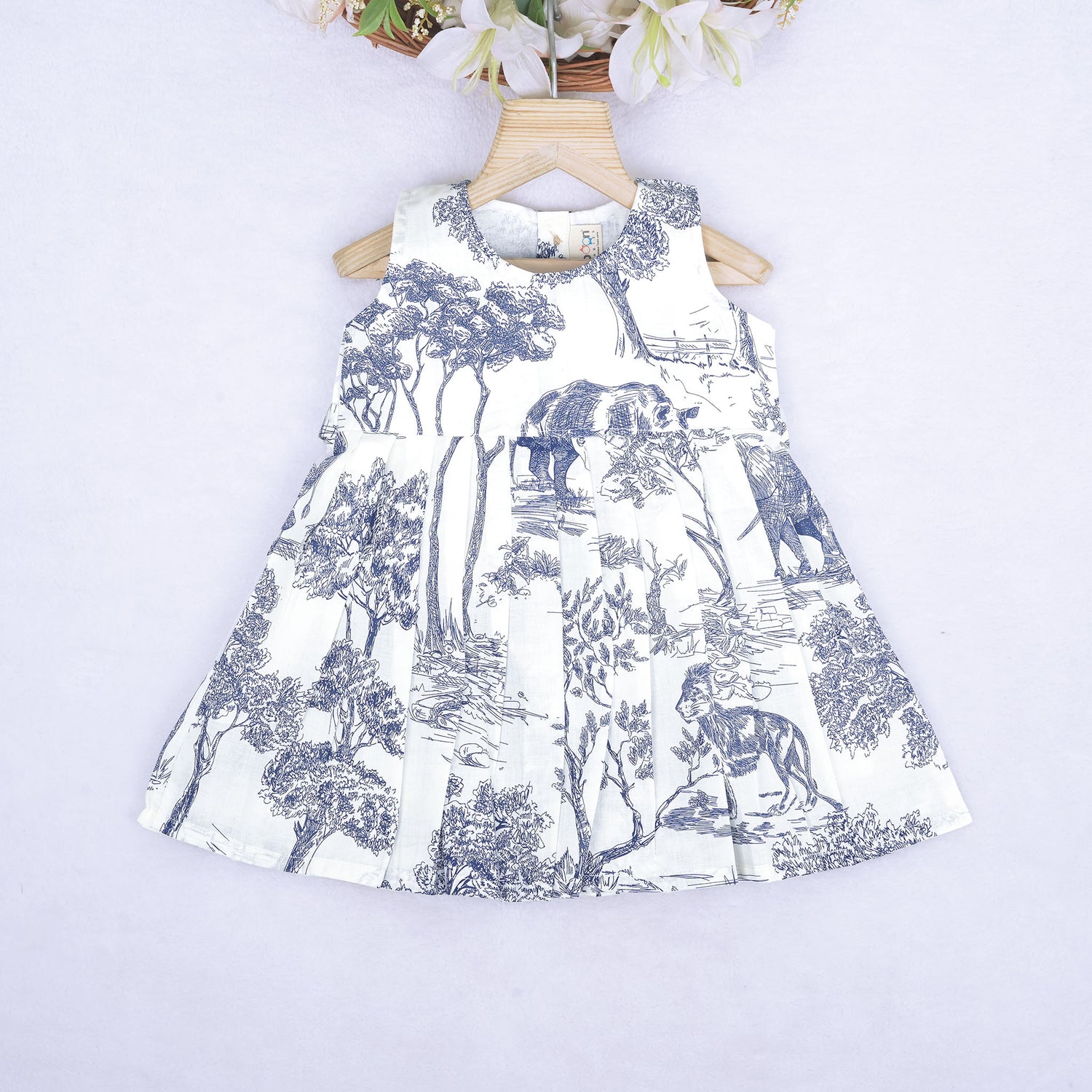Toddler girl wearing a white and blue sleeveless cotton frock with forest and elephant print – soft summer wear from Boon Babies, Coimbatore.