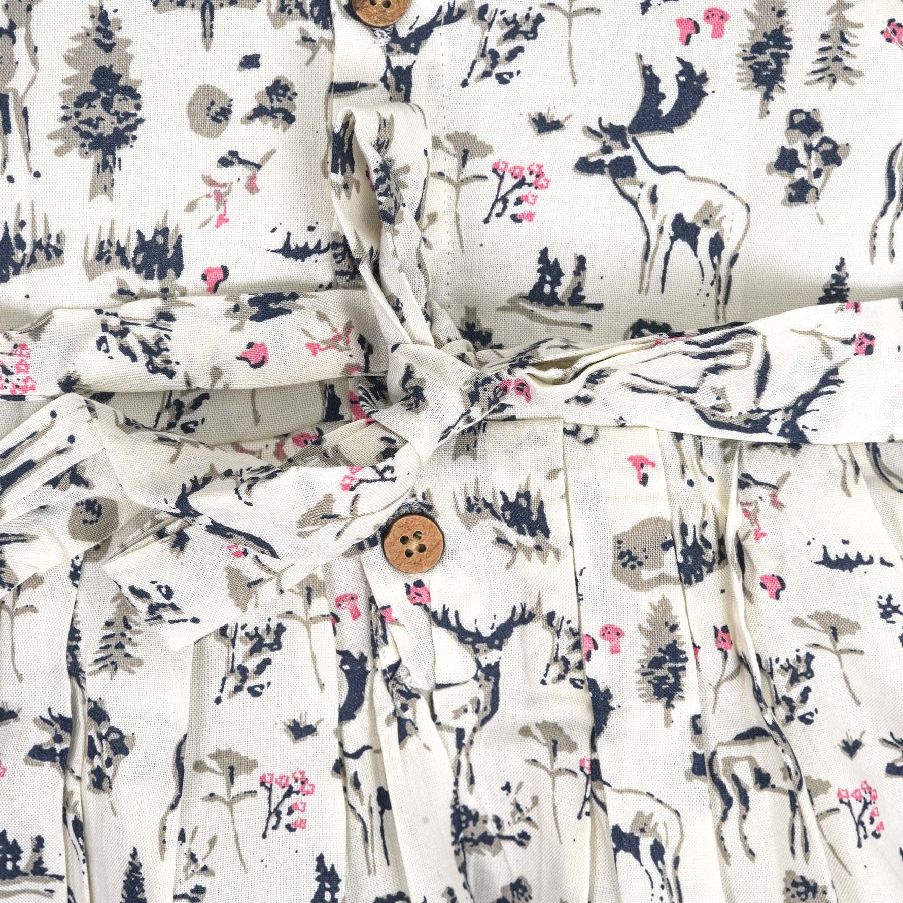 Toddler girl wearing a sleeveless white cotton frock with pink and green floral print – lightweight summer dress from Boon Babies, Coimbatore.