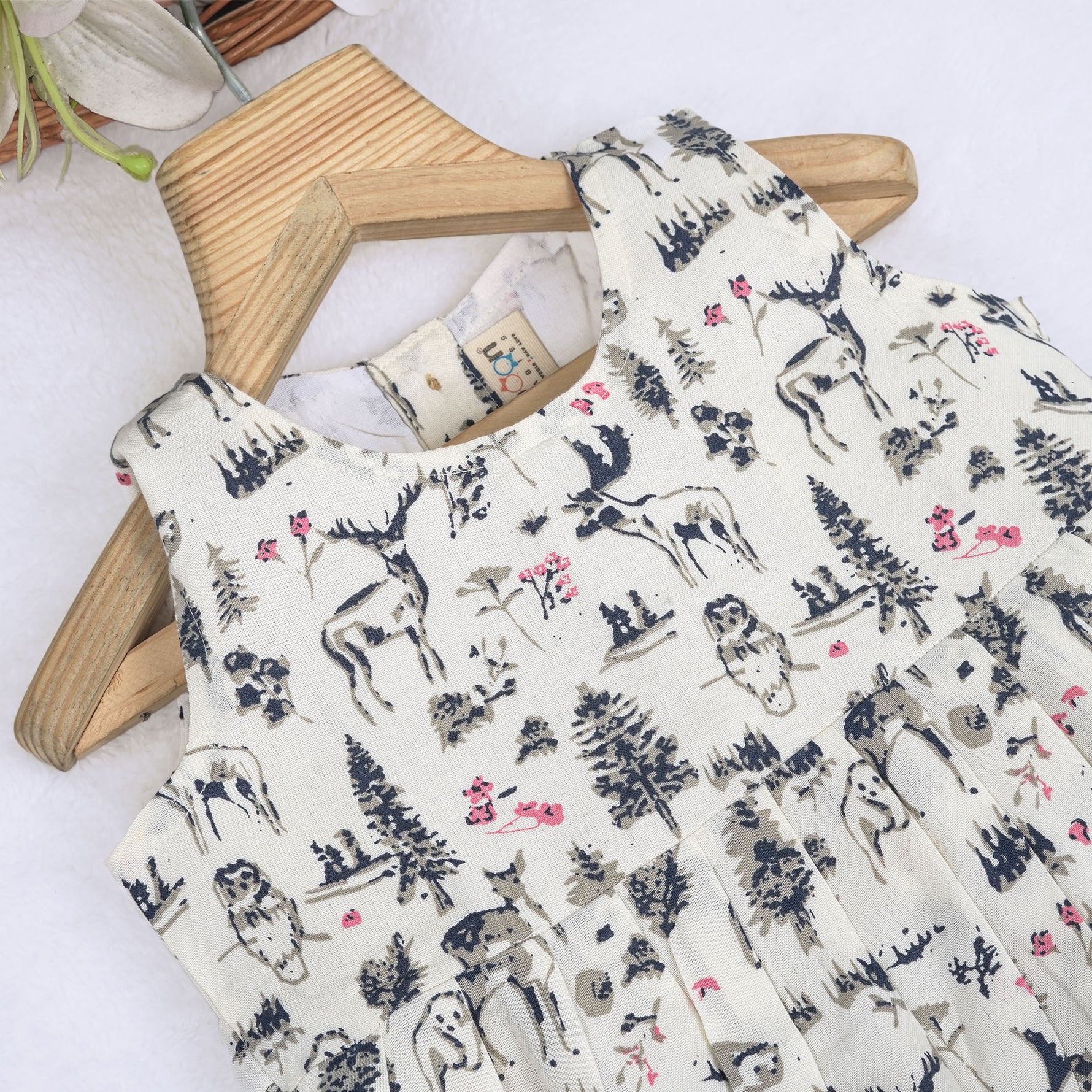 Toddler girl wearing a sleeveless white cotton frock with pink and green floral print – lightweight summer dress from Boon Babies, Coimbatore.