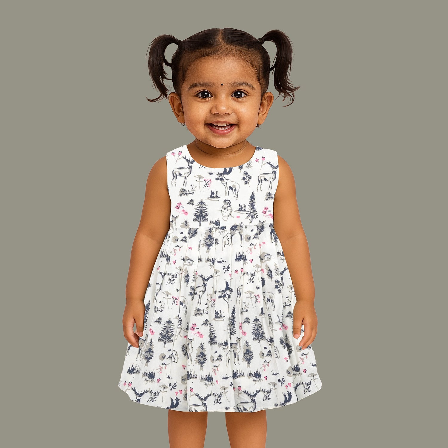 Toddler girl wearing a sleeveless white cotton frock with pink and green floral print – lightweight summer dress from Boon Babies, Coimbatore.