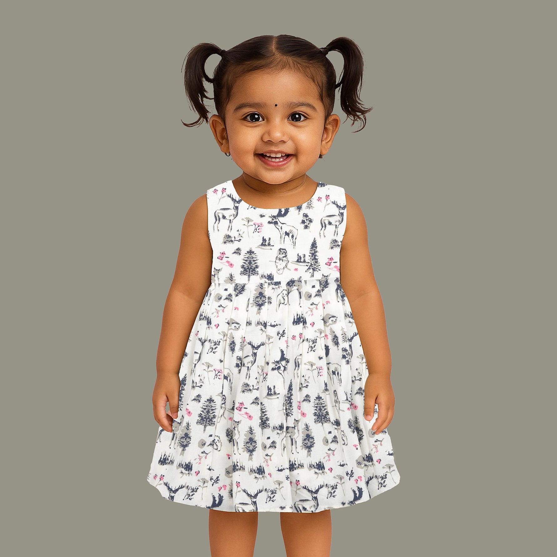 Toddler girl wearing a sleeveless white cotton frock with pink and green floral print – lightweight summer dress from Boon Babies, Coimbatore.