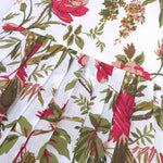 Toddler girl wearing a sleeveless white cotton frock with large pink floral and olive green leaf print – soft summer dress from Boon Babies, Coimbatore.