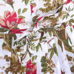 Toddler girl wearing a sleeveless white cotton frock with large pink floral and olive green leaf print – soft summer dress from Boon Babies, Coimbatore.