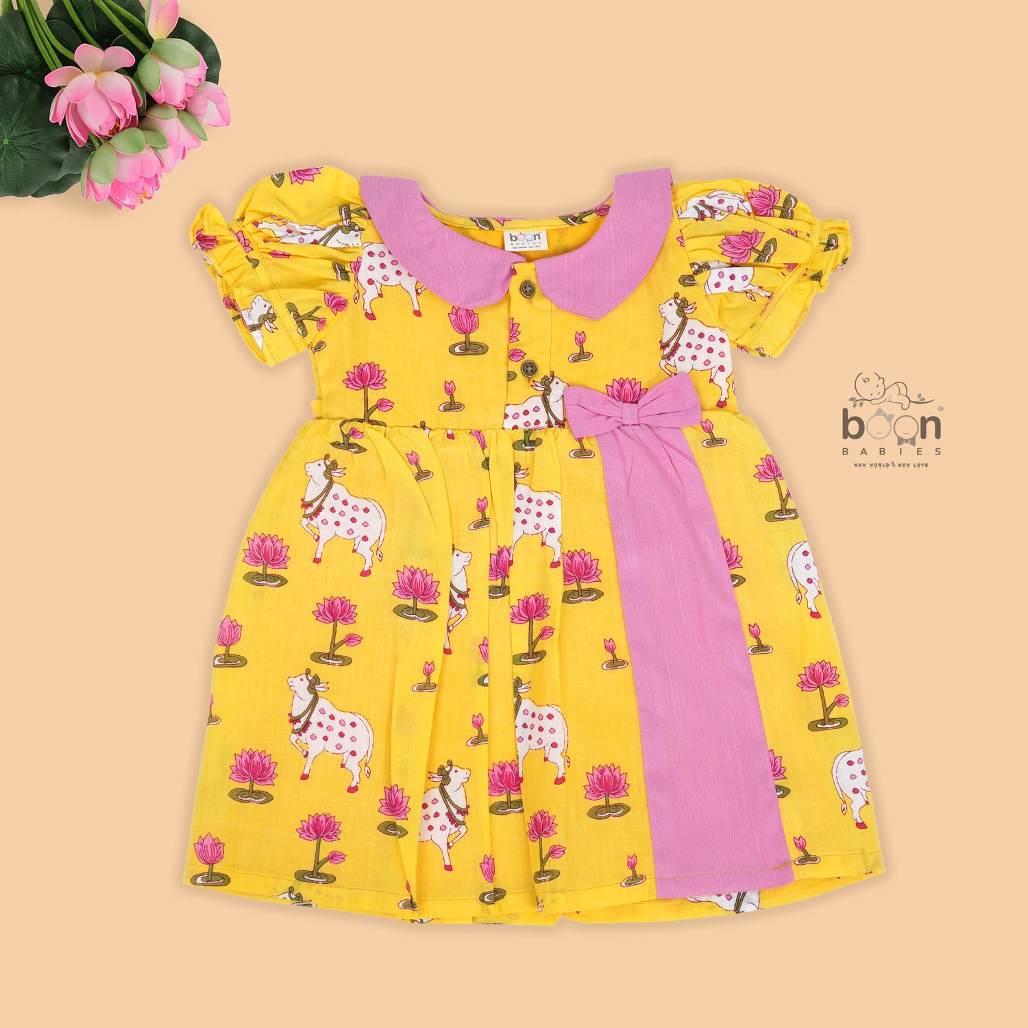 Yellow cotton puff frock with pink collar, bow tie & lotus print. Cute & comfy for girls aged 6M–4Y.