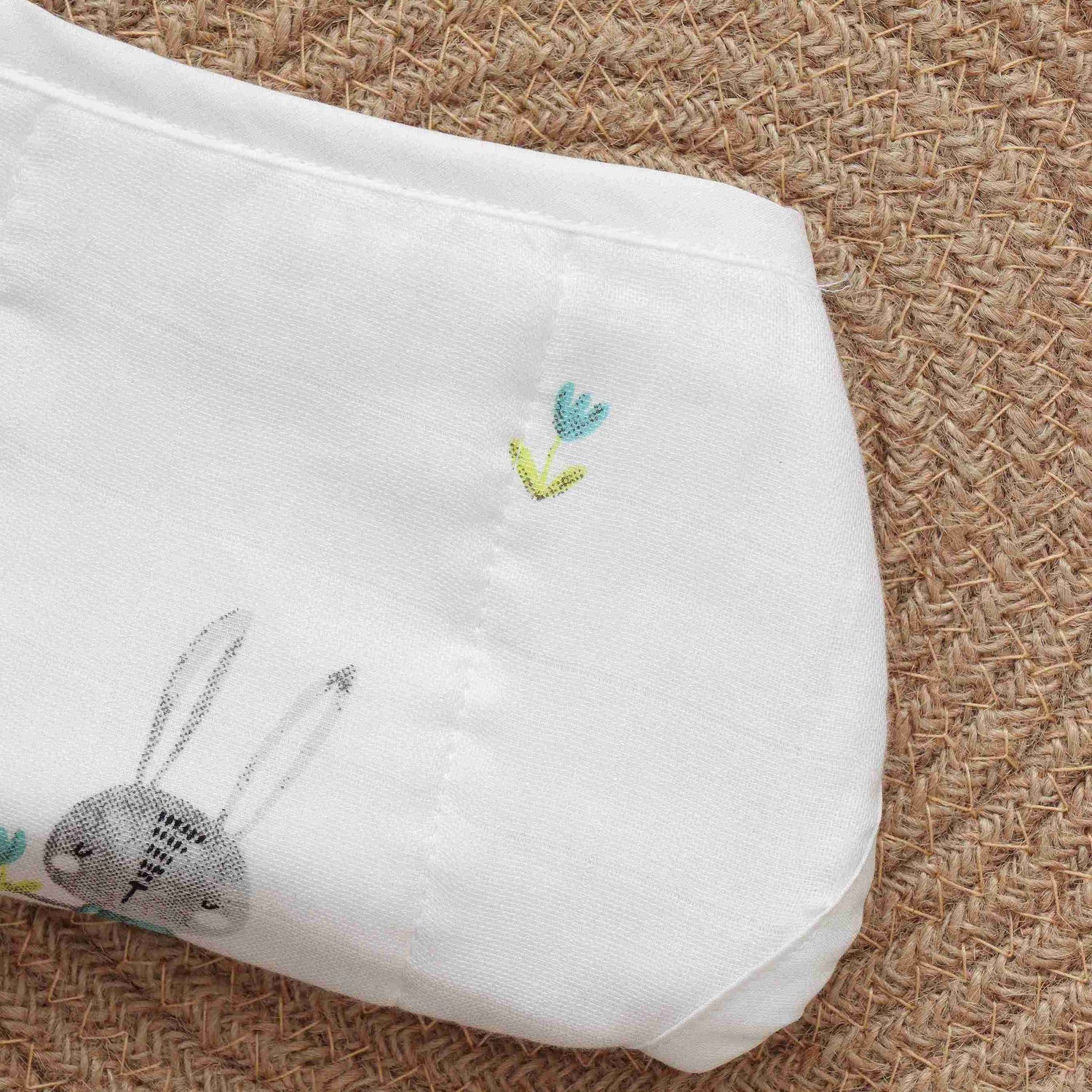 White muslin baby nappy with bunny print. For 0–3 months. Soft, reusable, and skin-friendly with easy tie closure.