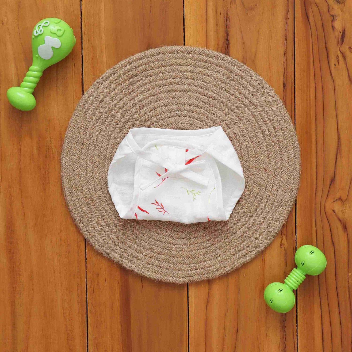 Soft muslin nappy with red & green leaf print. 0–3 months. Lightweight, reusable, and baby-friendly with tie closure.
