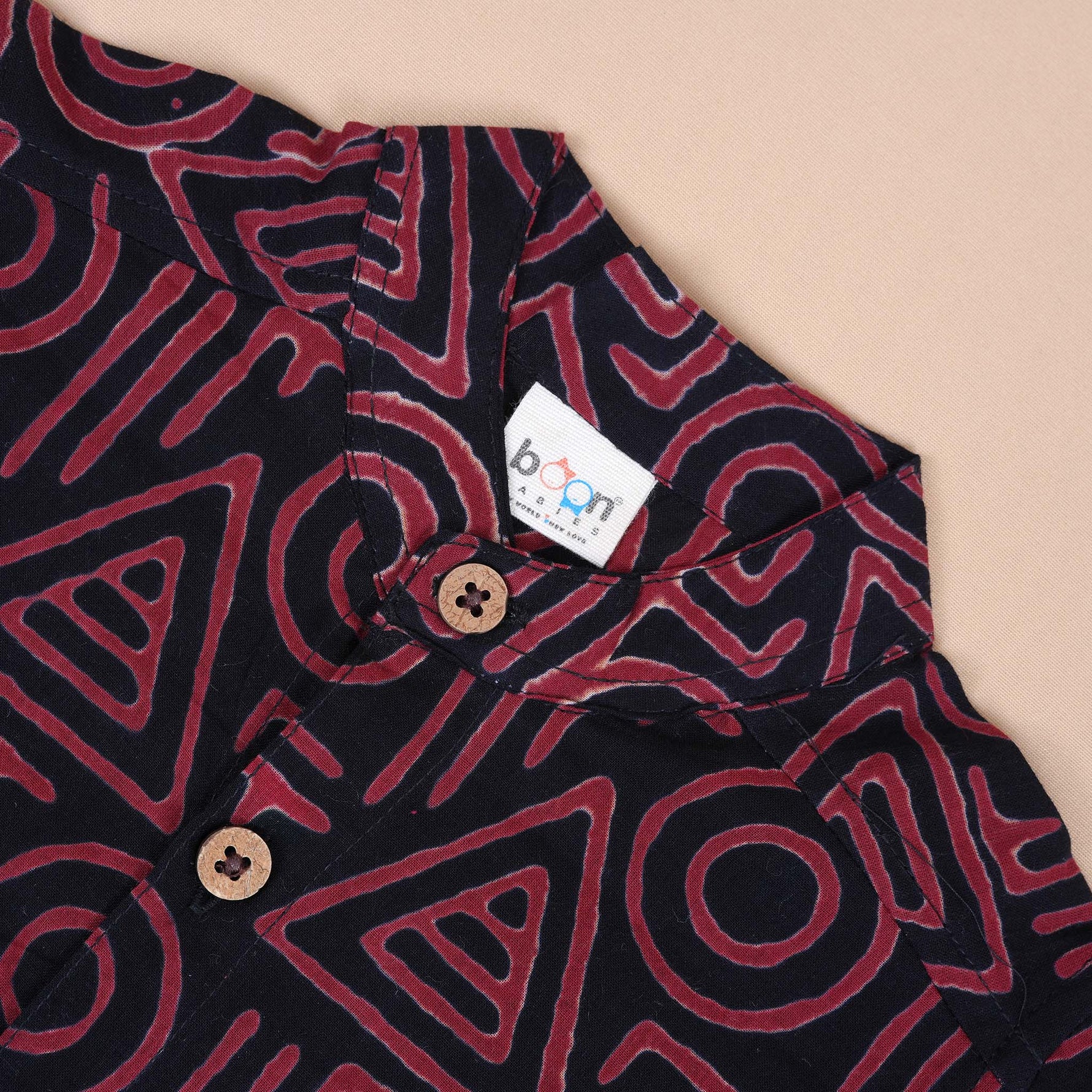 Red tribal printed cotton shirt with Chinese collar for babies by Boon Babies, featuring vibrant tribal design.