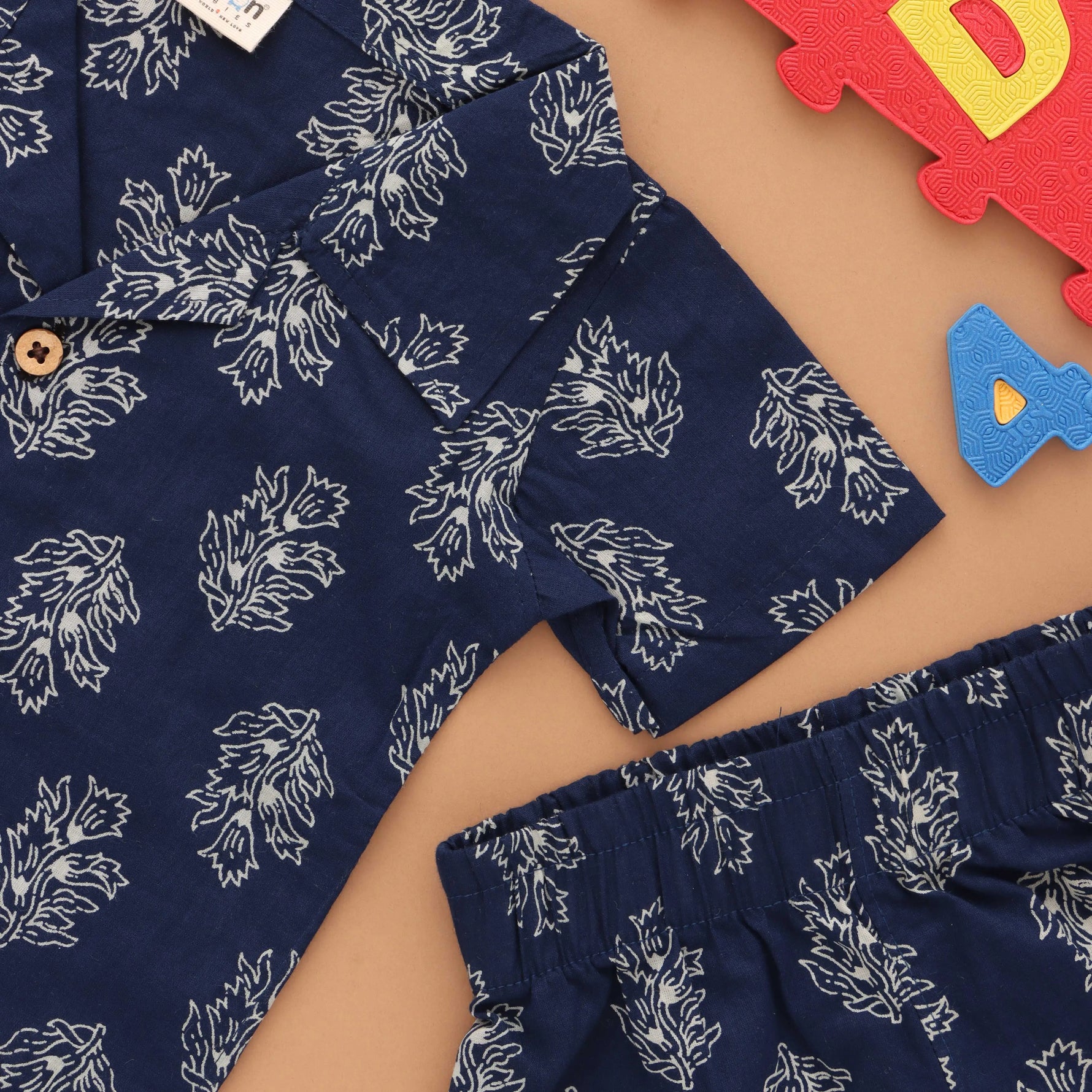 Trendy navy blue floral print boys' shirt and shorts set by Boon Babies with open collar, perfect for warm weather.