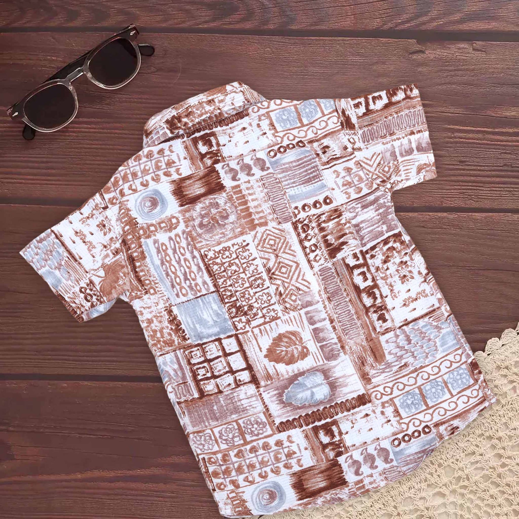 Boy wearing earthy brown tribal printed cotton shirt with straight collar, stylish Boon Babies design for boys aged 6-12 months.