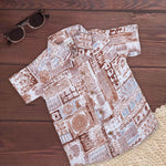 Boy wearing earthy brown tribal printed cotton shirt with straight collar, featuring vibrant tribal patterns, by Boon Babies.