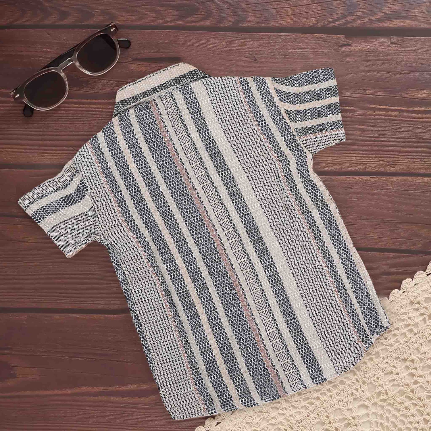 Boy wearing a red tribal-inspired printed cotton shirt with a straight collar from Boon Babies for ages 6-12 months.